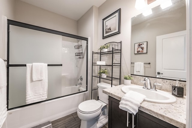 full bathroom featuring vanity, toilet, and shower / bath combination with glass door