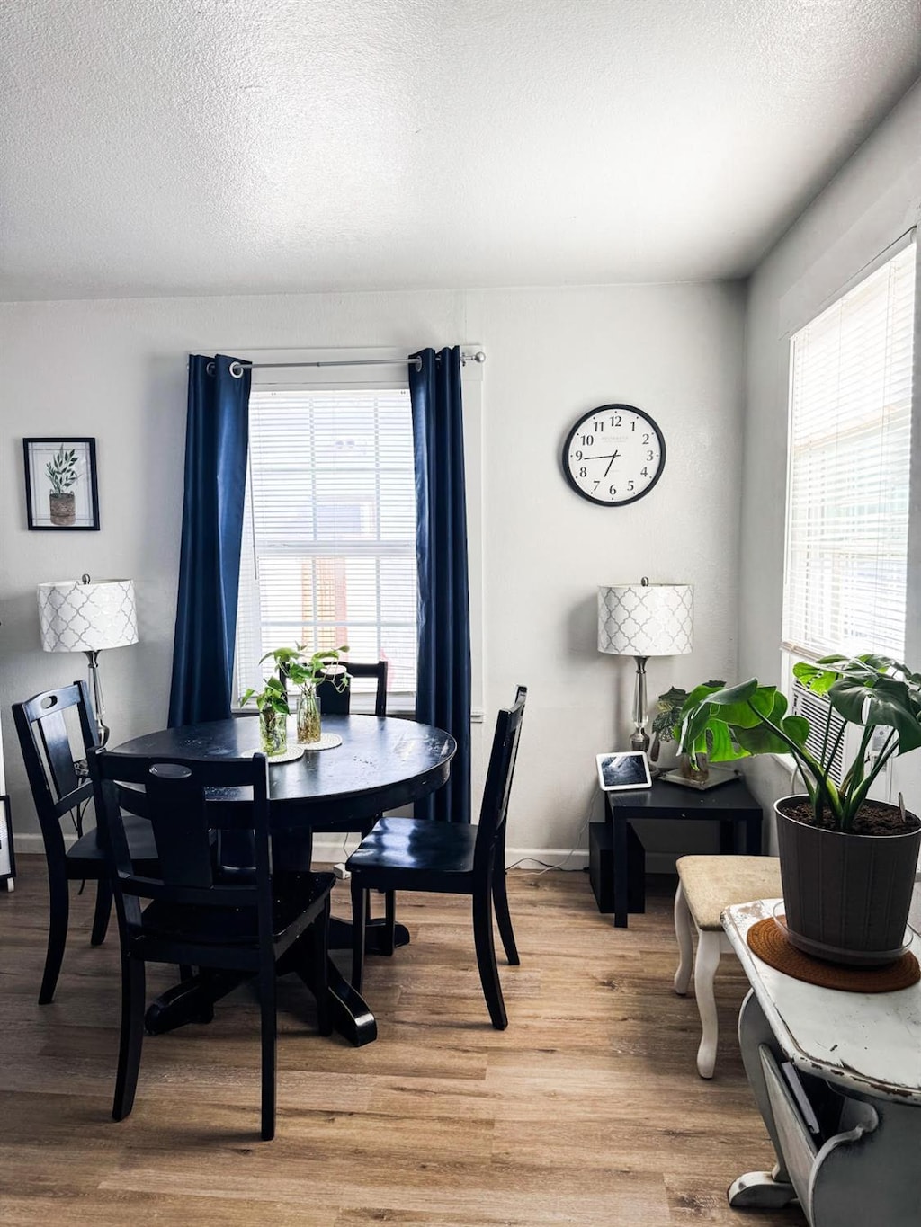 dining area featuring a textured ceiling, light wood-type flooring, and a wealth of natural light