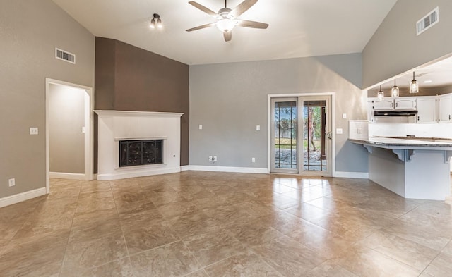 unfurnished living room with ceiling fan and vaulted ceiling