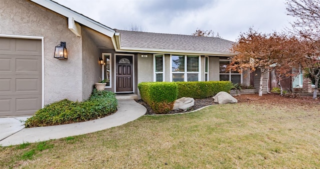 single story home with a garage and a front lawn