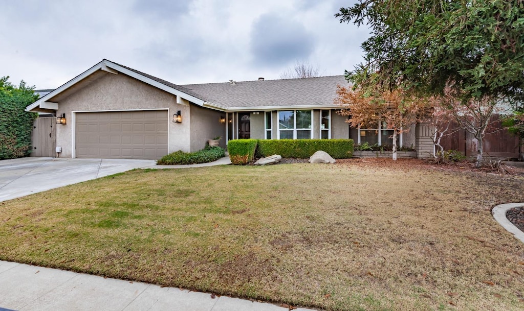 ranch-style house featuring a front yard and a garage