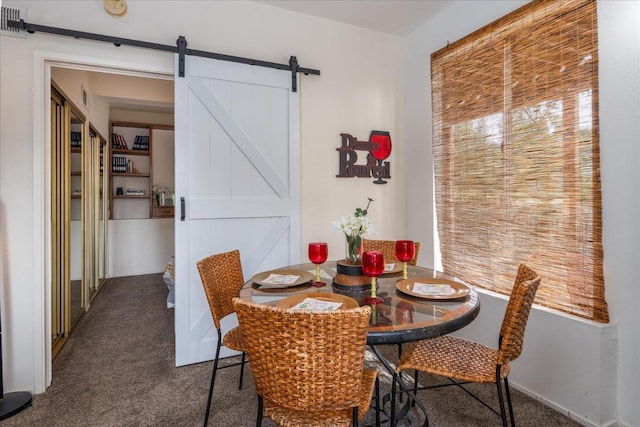 dining room featuring a barn door and dark carpet