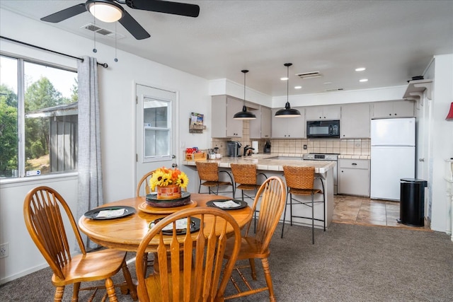 dining space featuring carpet flooring and ceiling fan