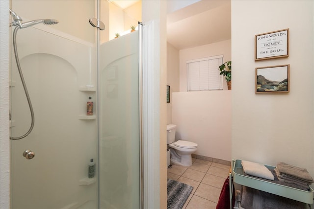 bathroom featuring tile patterned flooring, toilet, and a shower with door