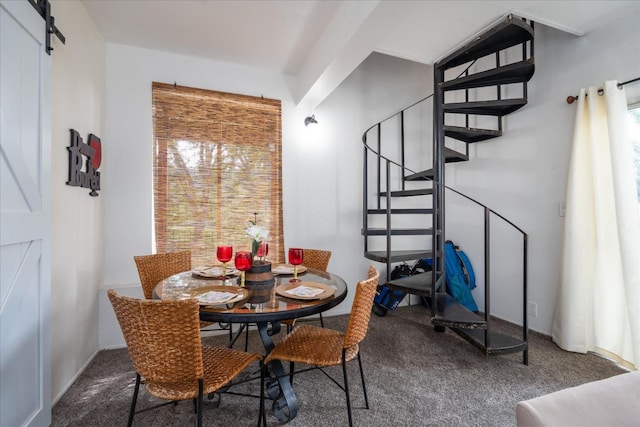 carpeted dining space featuring a barn door