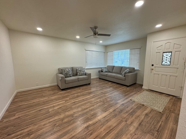 living room with dark hardwood / wood-style flooring and ceiling fan