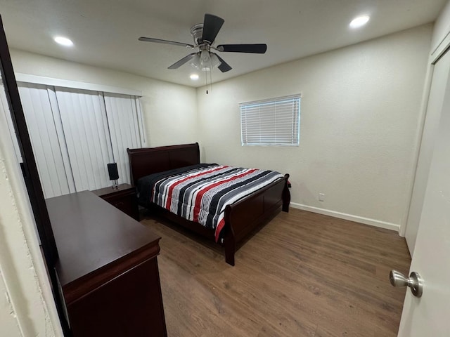 bedroom with dark hardwood / wood-style floors and ceiling fan