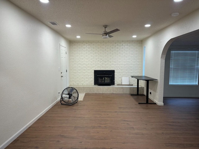 interior space with a textured ceiling, ceiling fan, and dark wood-type flooring