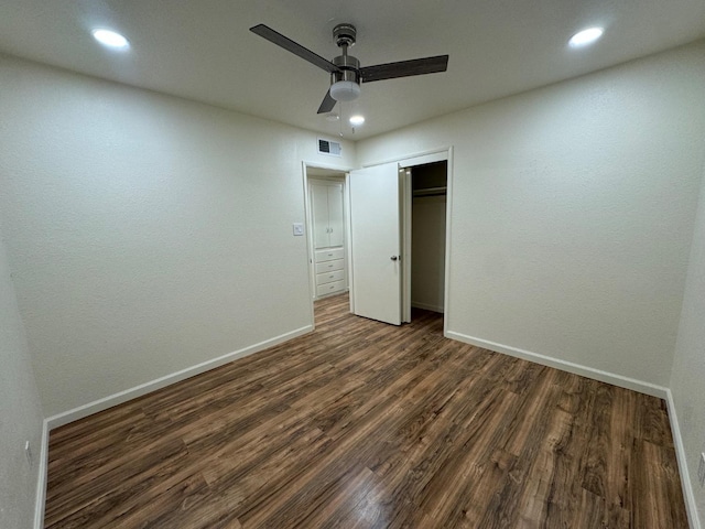 unfurnished bedroom with ceiling fan, dark hardwood / wood-style floors, and a closet