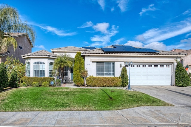 view of front of property featuring solar panels, a garage, and a front lawn