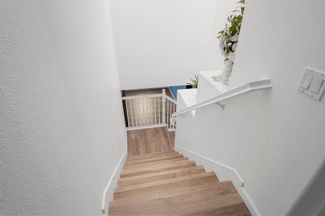 stairs featuring hardwood / wood-style floors