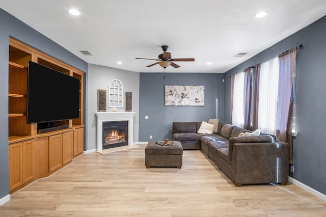 living room with ceiling fan and light hardwood / wood-style flooring