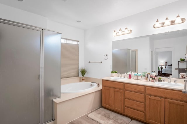 bathroom featuring hardwood / wood-style floors, vanity, and independent shower and bath