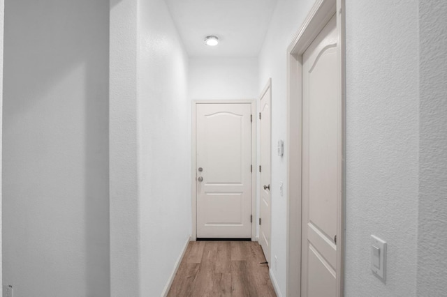 hallway with light hardwood / wood-style floors