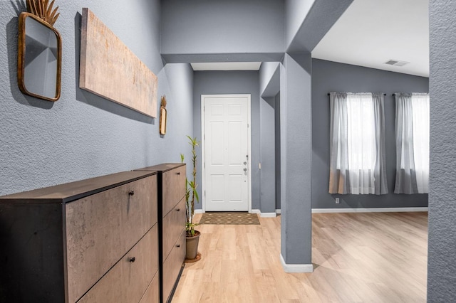 foyer featuring light wood-type flooring and lofted ceiling