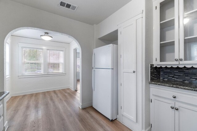 kitchen featuring white cabinets, backsplash, white fridge, and light hardwood / wood-style floors