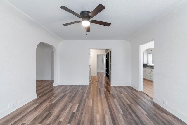 spare room featuring ceiling fan, dark hardwood / wood-style flooring, and sink