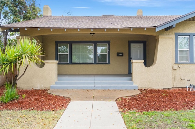 view of exterior entry with covered porch