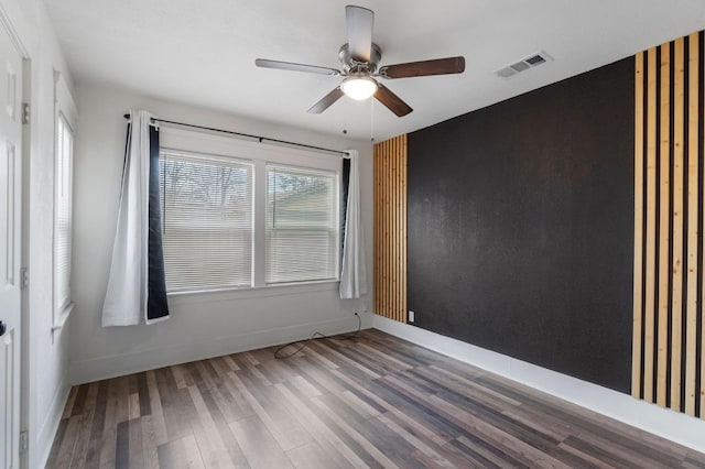 unfurnished room featuring hardwood / wood-style floors, ceiling fan, and a wealth of natural light