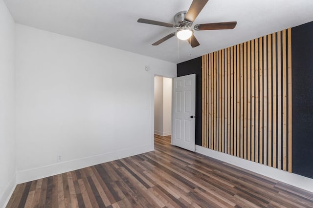 unfurnished room featuring ceiling fan and dark wood-type flooring