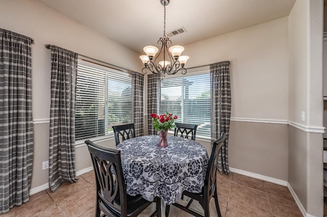 tiled dining area with an inviting chandelier