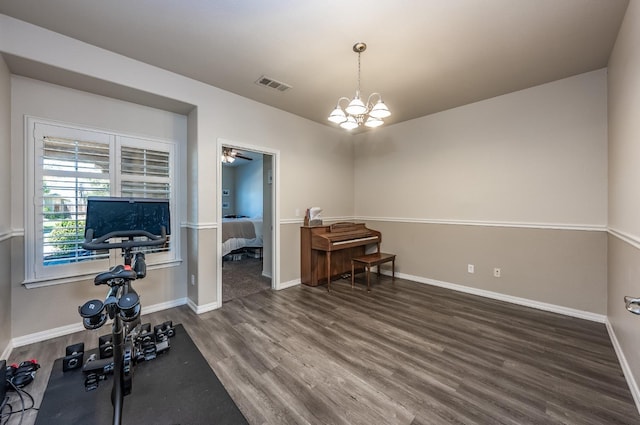 workout area featuring dark hardwood / wood-style floors and a chandelier