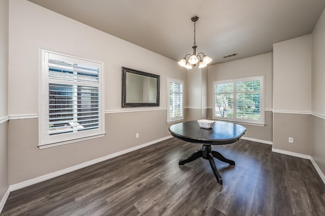 unfurnished dining area with dark hardwood / wood-style floors and a notable chandelier