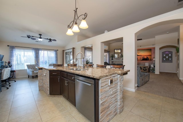 kitchen with sink, dark brown cabinets, light stone countertops, an island with sink, and stainless steel dishwasher