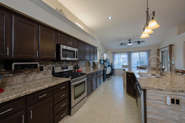 kitchen with sink, decorative light fixtures, vaulted ceiling, and appliances with stainless steel finishes