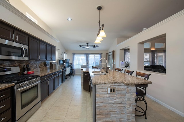 kitchen featuring appliances with stainless steel finishes, sink, a breakfast bar area, and lofted ceiling