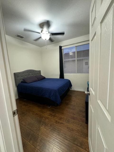 bedroom with ceiling fan and dark wood-type flooring