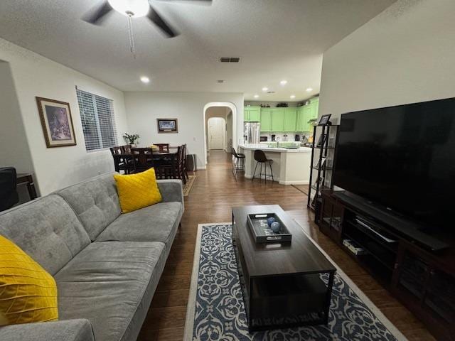 living room with dark hardwood / wood-style floors and ceiling fan