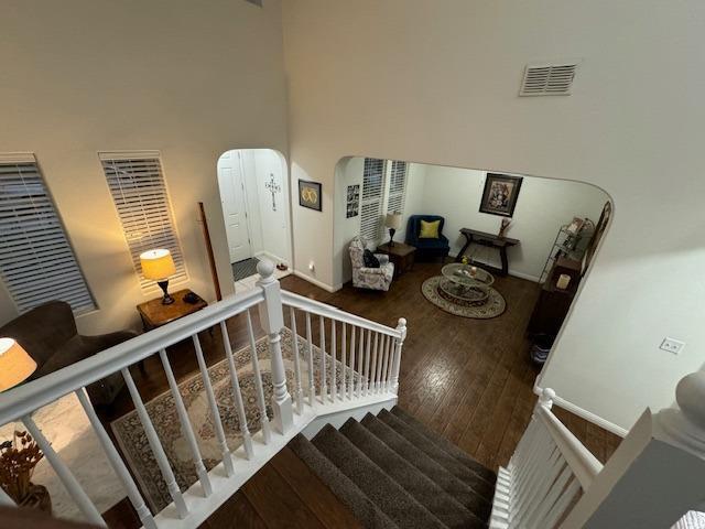 stairway featuring a high ceiling and hardwood / wood-style flooring