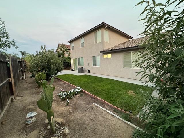 rear view of house with a yard and central air condition unit