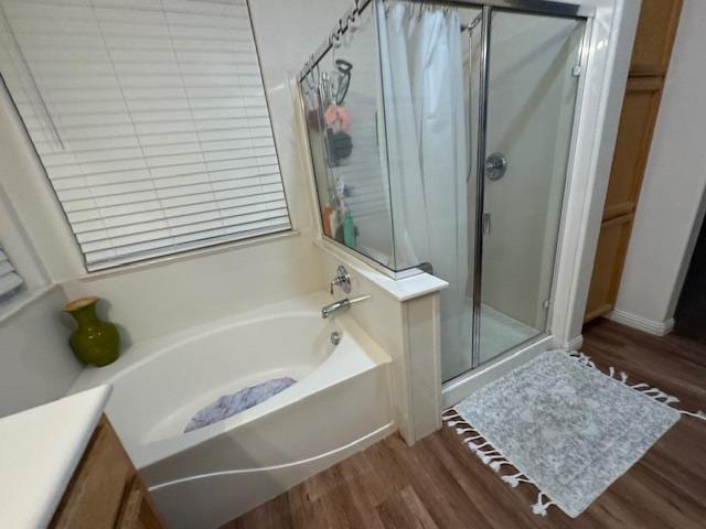 bathroom featuring separate shower and tub and wood-type flooring