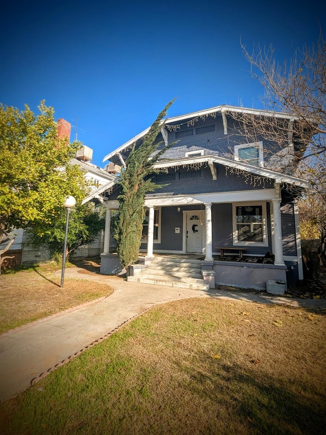 view of front facade featuring a front lawn and covered porch