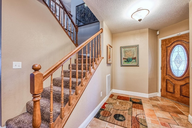 entryway with a textured ceiling