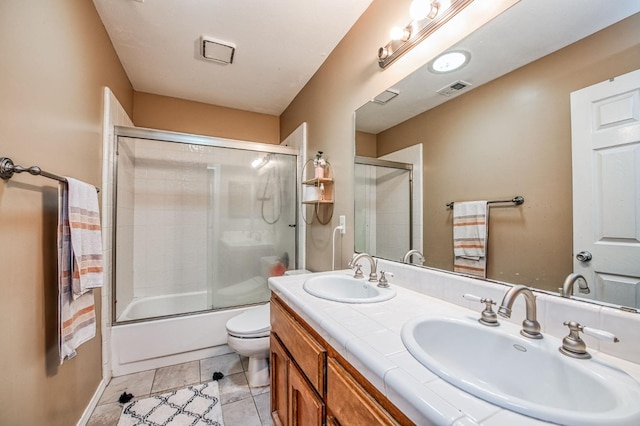 full bathroom with tile patterned floors, toilet, vanity, and combined bath / shower with glass door