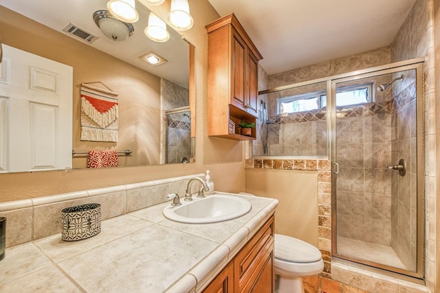 bathroom featuring vanity, toilet, and an enclosed shower