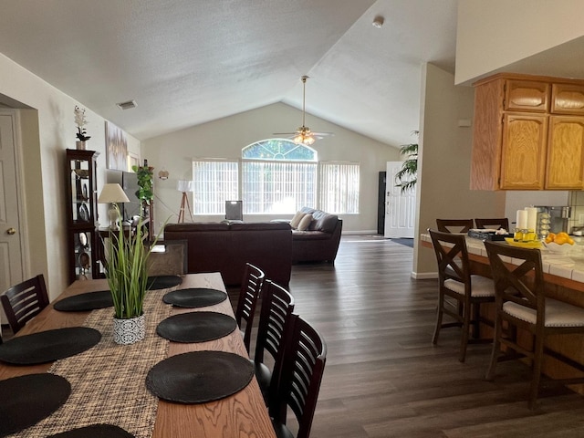 dining area featuring vaulted ceiling, ceiling fan, and dark hardwood / wood-style floors