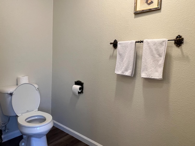 bathroom with toilet and hardwood / wood-style flooring