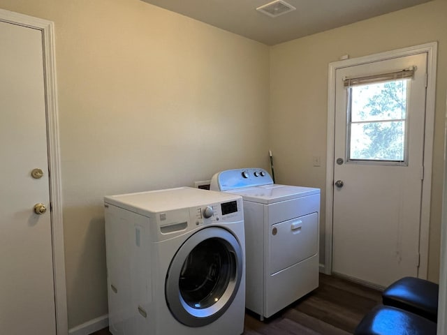 washroom with dark wood-style floors, laundry area, washing machine and clothes dryer, and visible vents