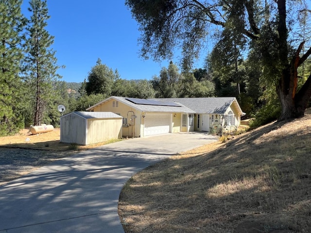 ranch-style house featuring solar panels and a garage