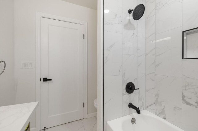 full bathroom featuring vanity, tiled shower / bath combo, and toilet