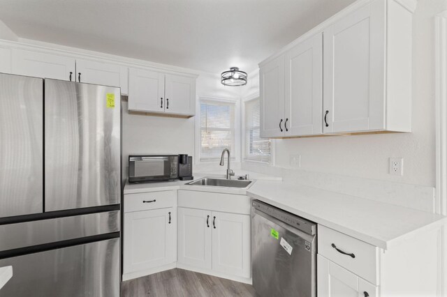 kitchen featuring sink, white cabinetry, stainless steel appliances, and light wood-type flooring