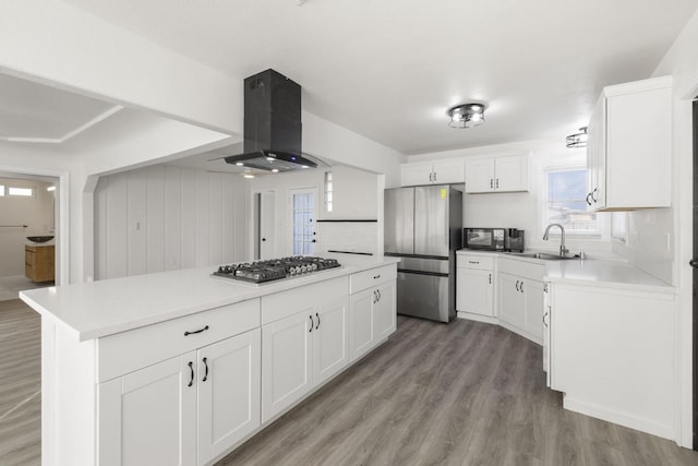 kitchen featuring appliances with stainless steel finishes, sink, white cabinetry, and exhaust hood