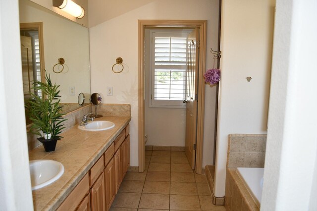 bathroom with toilet, vanity, a relaxing tiled tub, and tile patterned floors