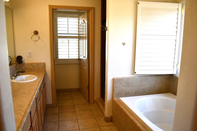 bathroom with tile patterned floors, vanity, and tiled tub