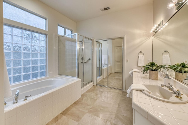 bathroom featuring a shower with door and vanity