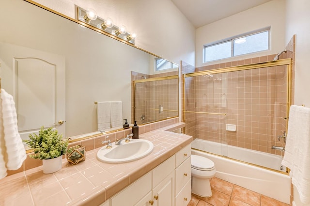 full bathroom with vanity, combined bath / shower with glass door, tile patterned floors, and toilet